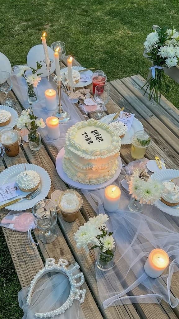 Bride to be torta gyertyákkal és virágokkal egy piknikasztalon